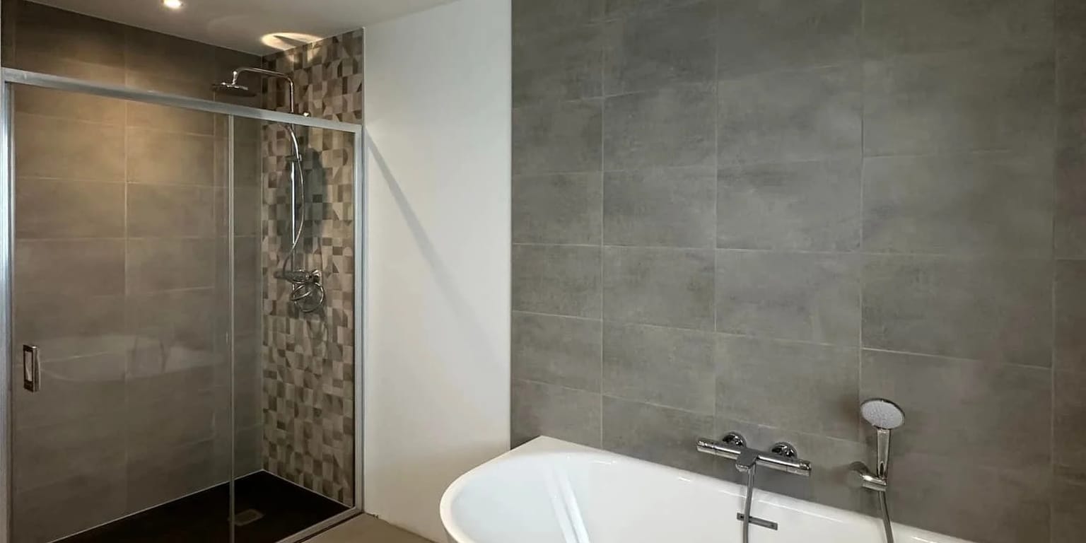 Carrelage gris grand format et frise mosaïque dans la douche, posés par SASU Max